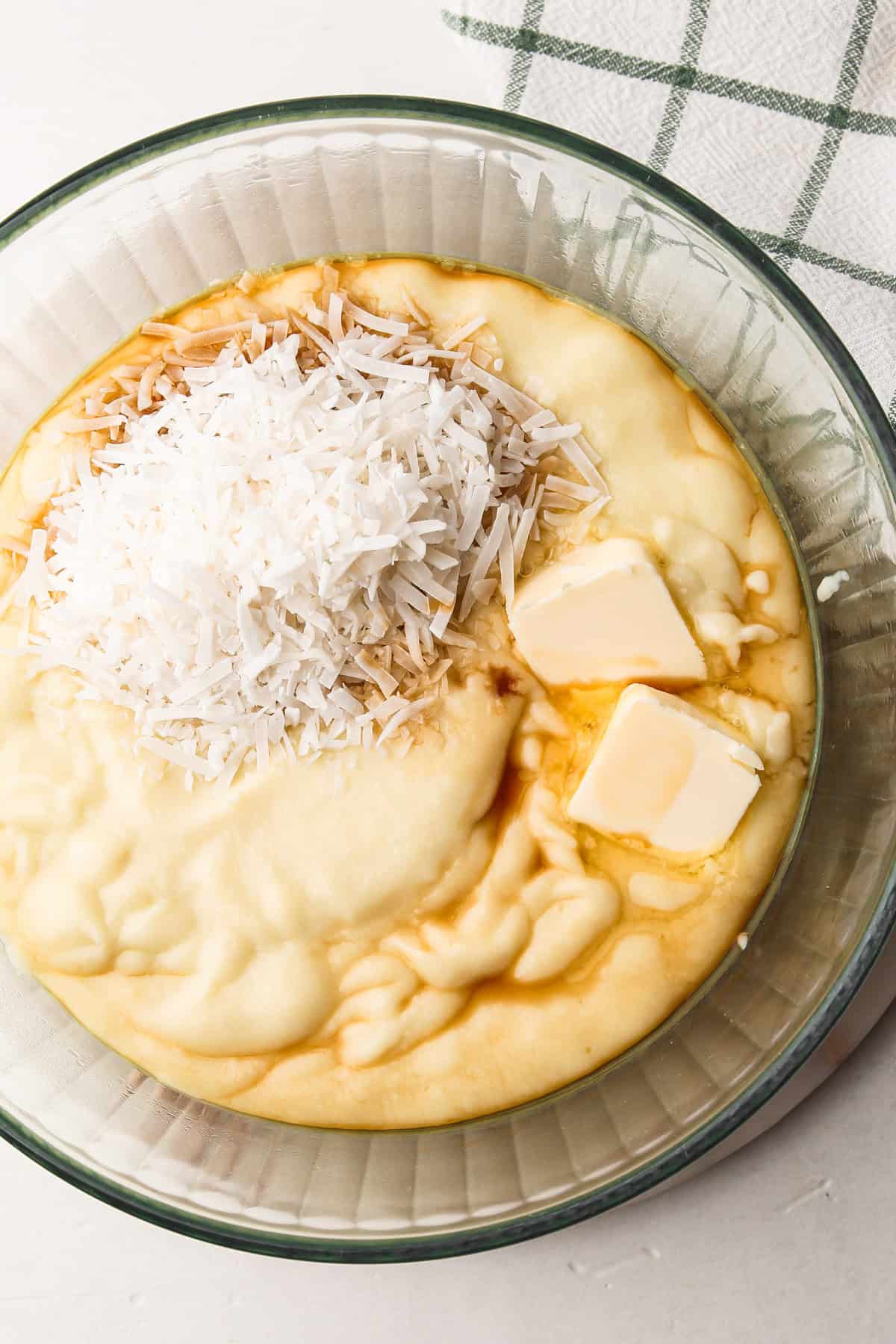 Adding shredded coconut, butter, and vanilla to hot pudding for coconut cream pie.