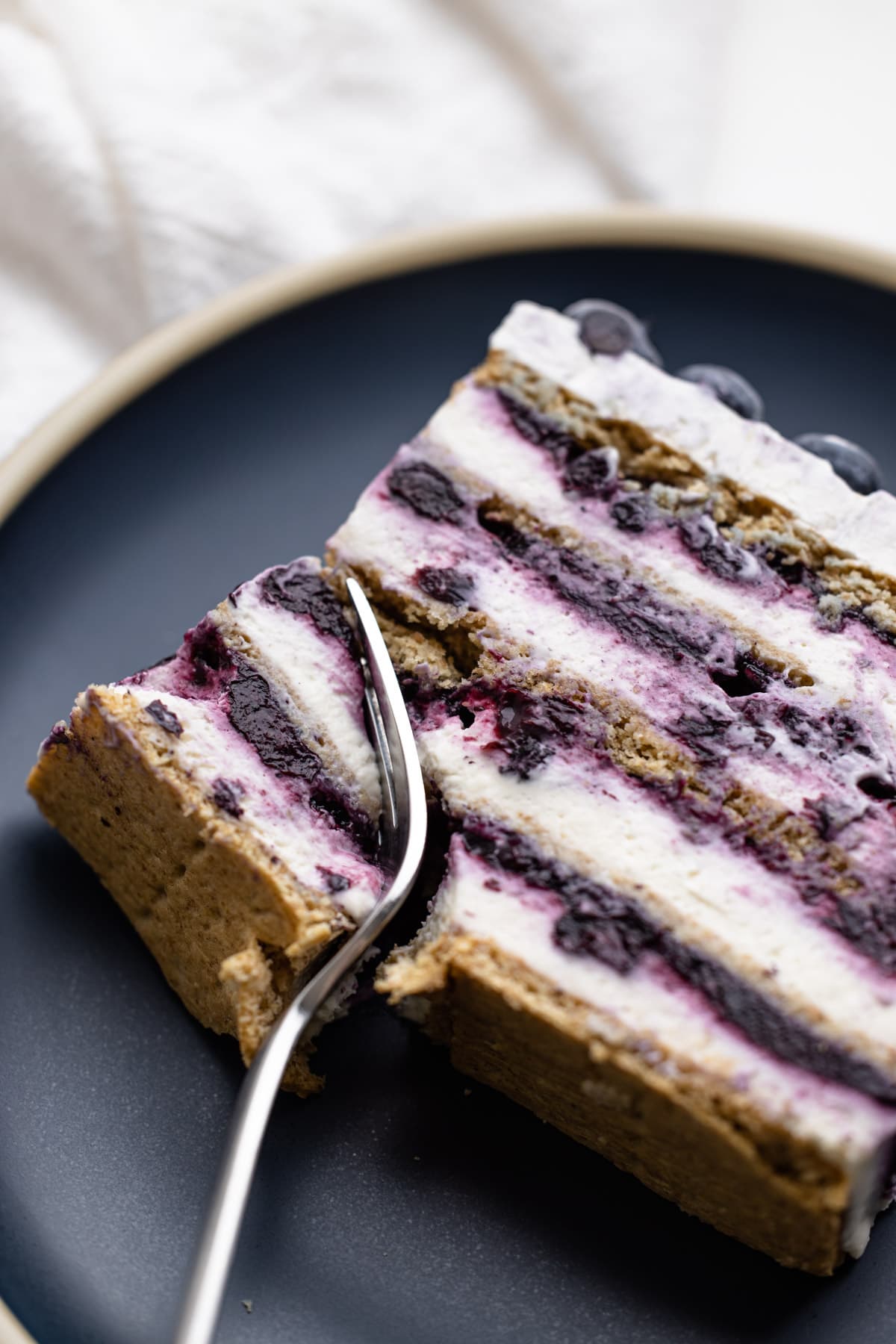 A slice of blueberry icebox cake on a blue plate.