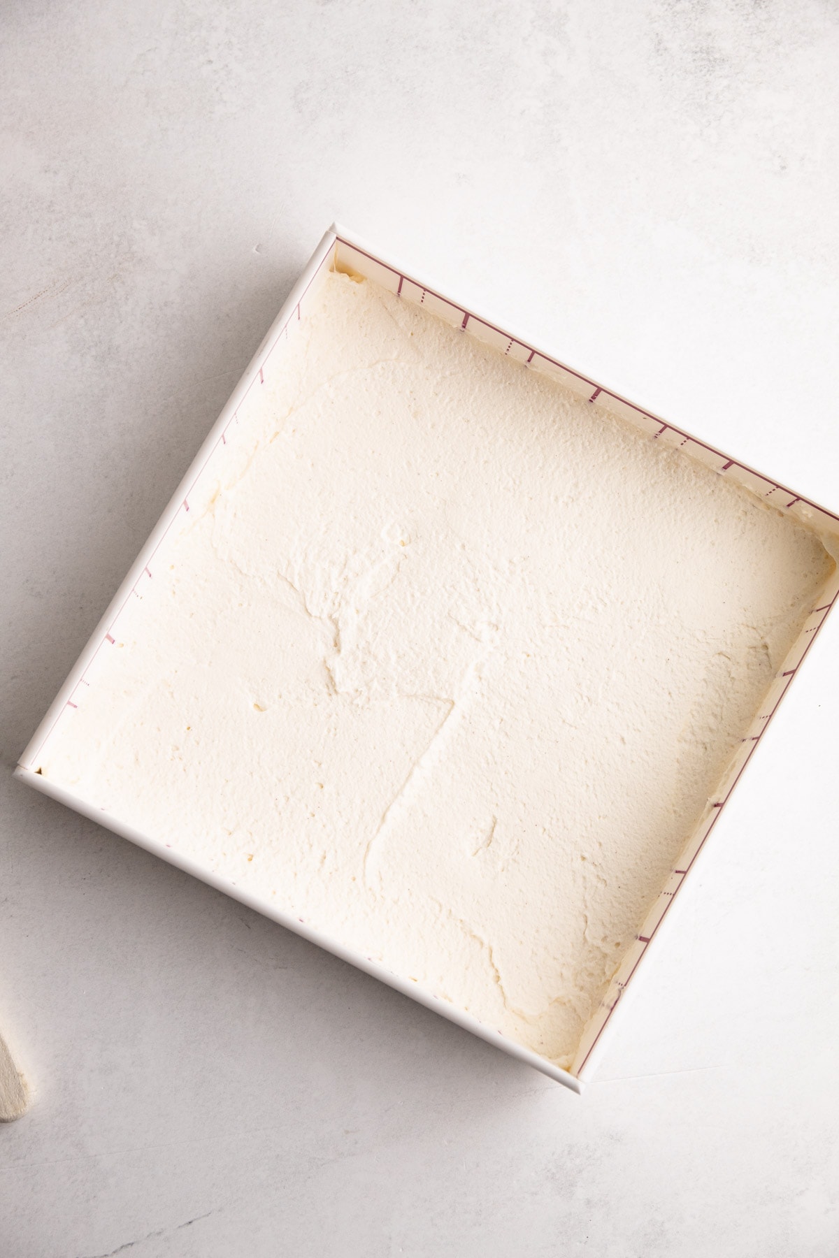 Mascarpone filling spread in a thin layer for a blueberry icebox cake.