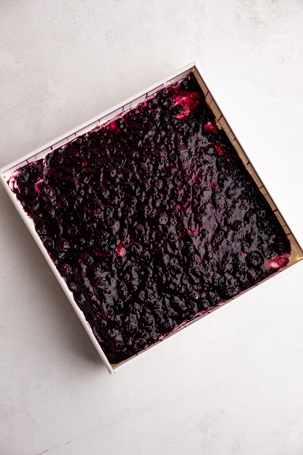 A layer of blueberry pie filling for the assembly of pie filling.