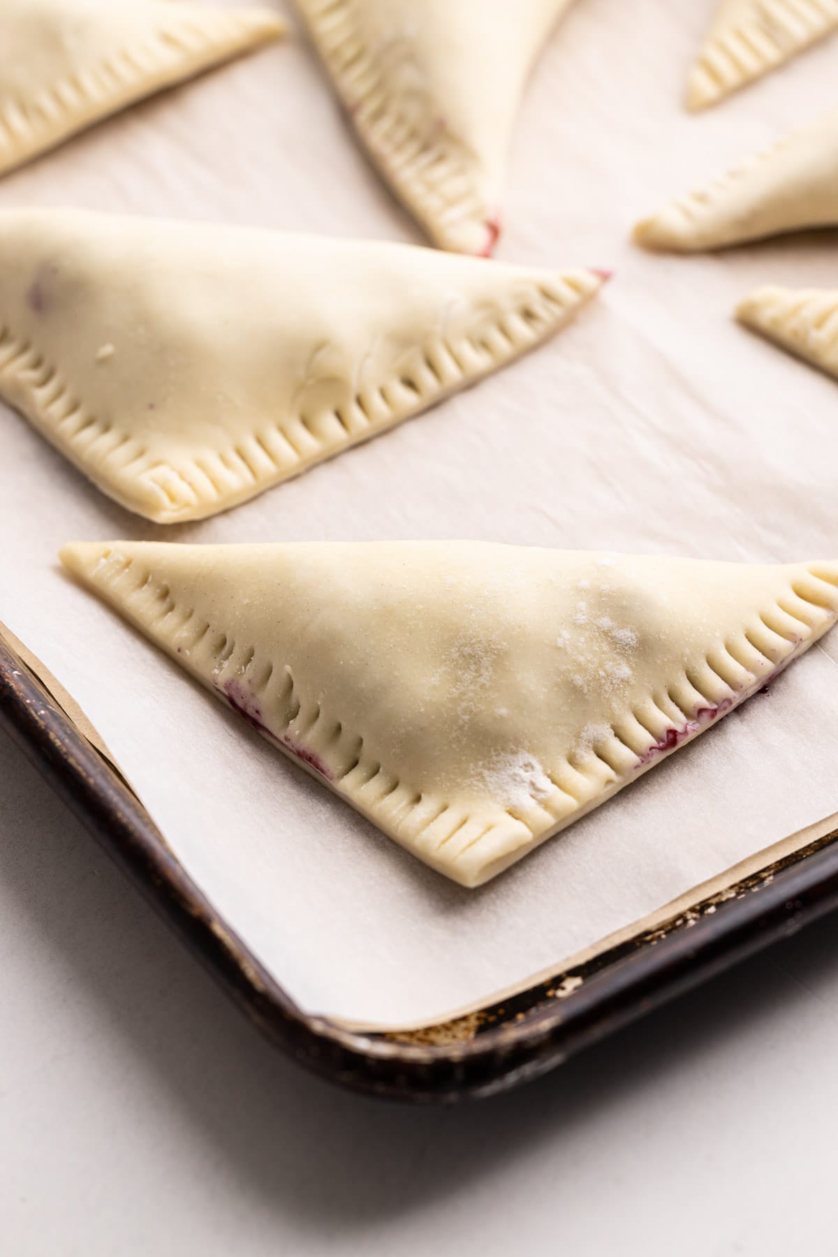 Blueberry turnovers on a baking tray.