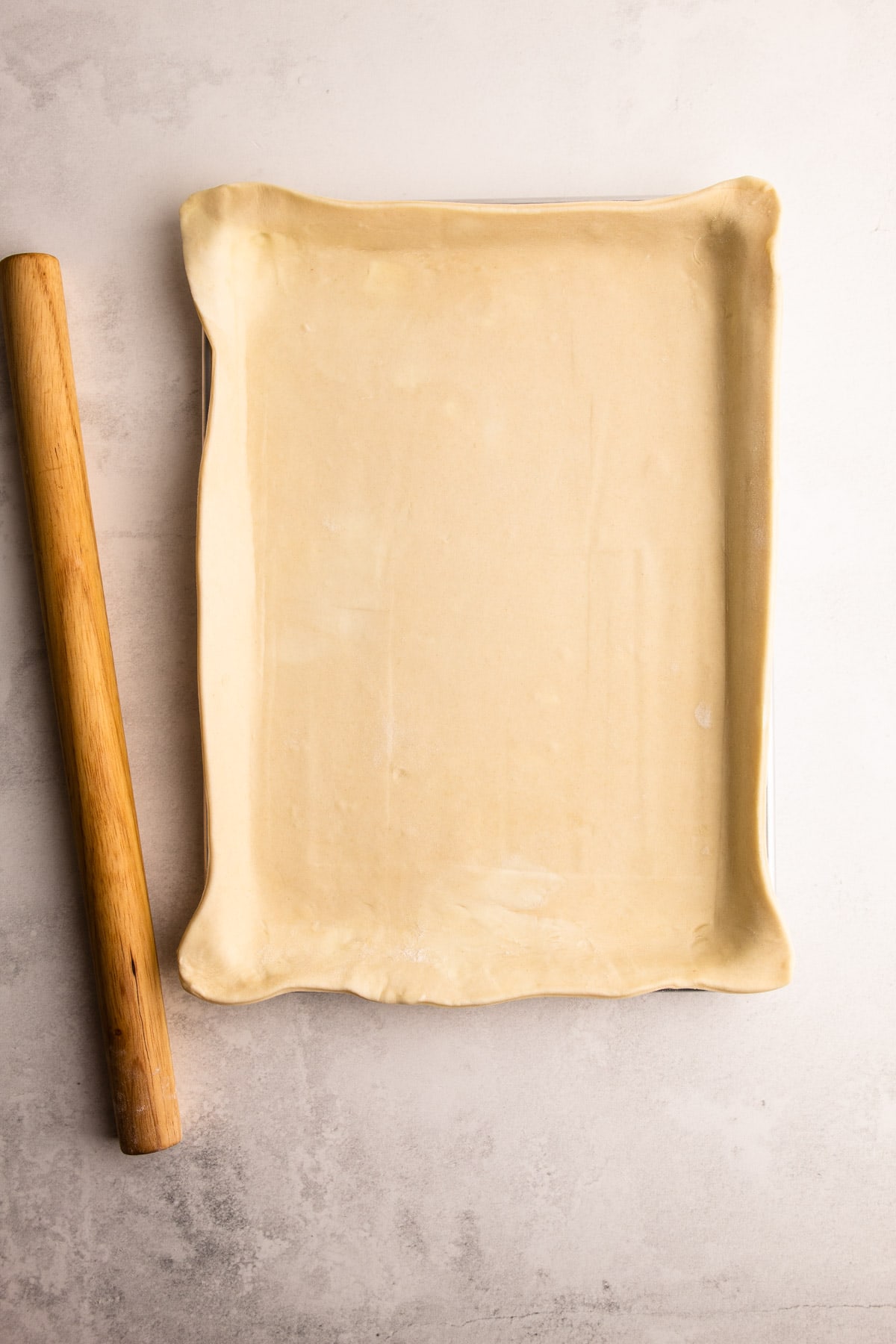 A pie crust inside of a jelly roll pan.