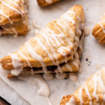 Cherry Turnovers on a sheet pan with a vanilla glaze.