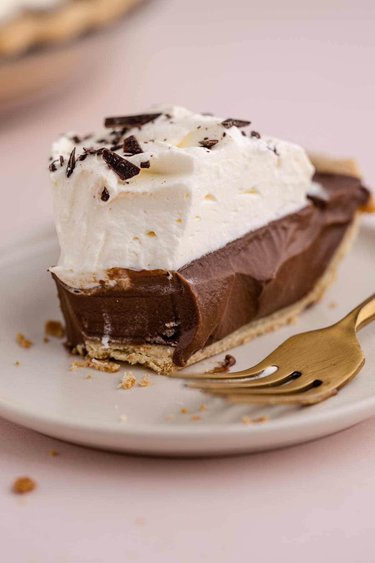 A slice of chocolate cream pie with a bite taken out of it.