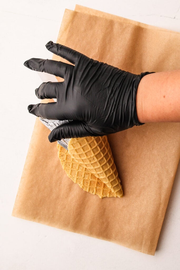Rolling waffle cones around a waffle cone form.