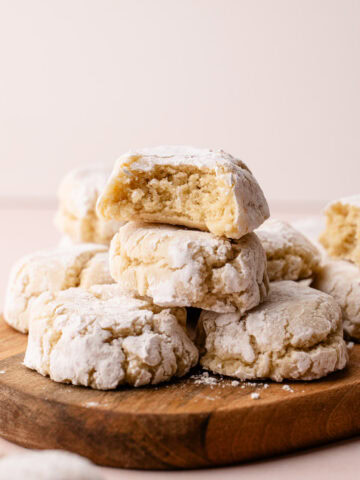 Italian almond cookies baked and stacked with a bit taken from them to reveal the tender interior.