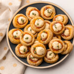 Baked cream cheese and pepper jelly bites on a plate.