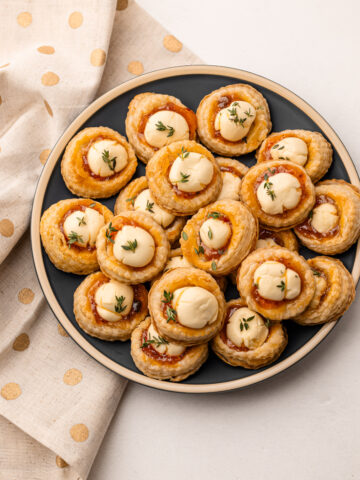 Baked cream cheese and pepper jelly bites on a plate.