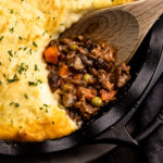 Beef shepherd's pie with a portion removed to reveal the savory beef filling.