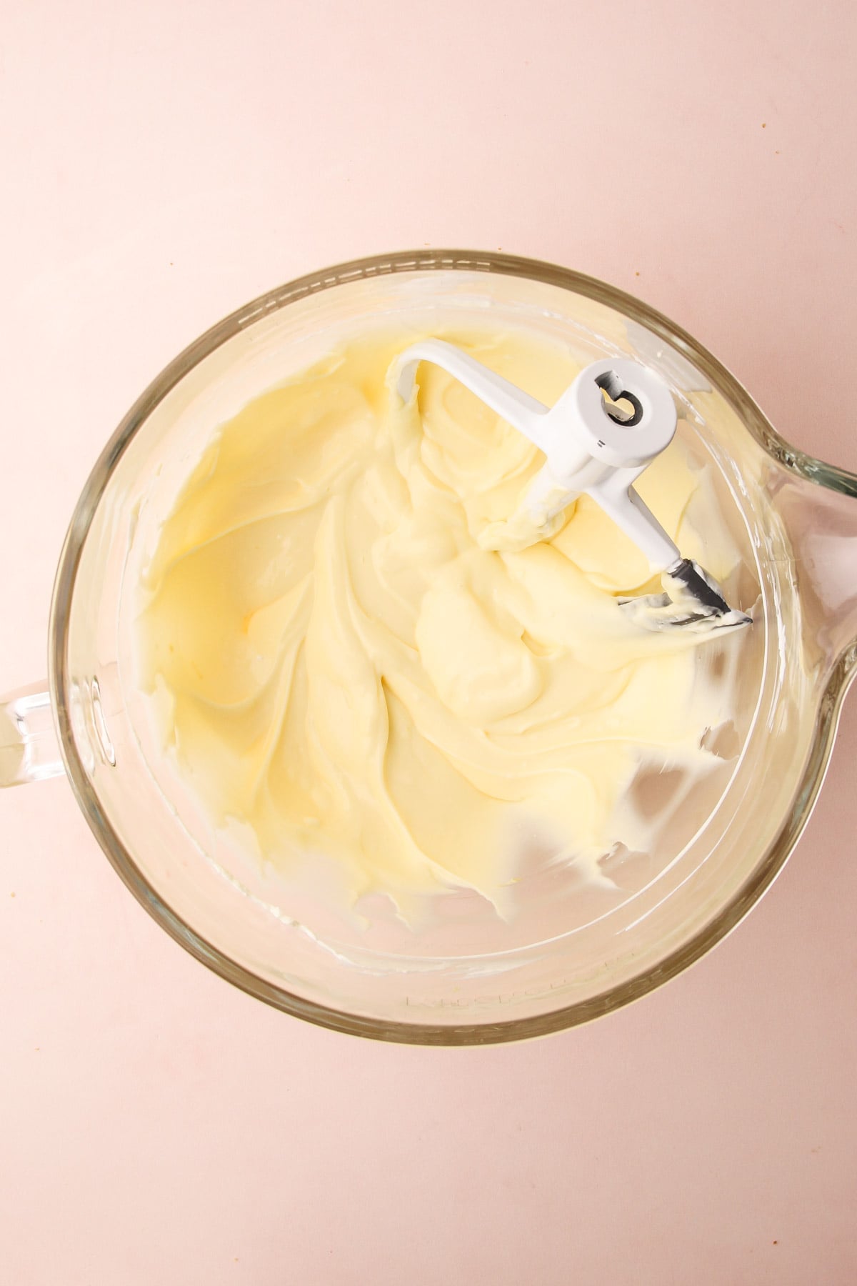 A bowl of cream cheese in an electric mixing bowl.